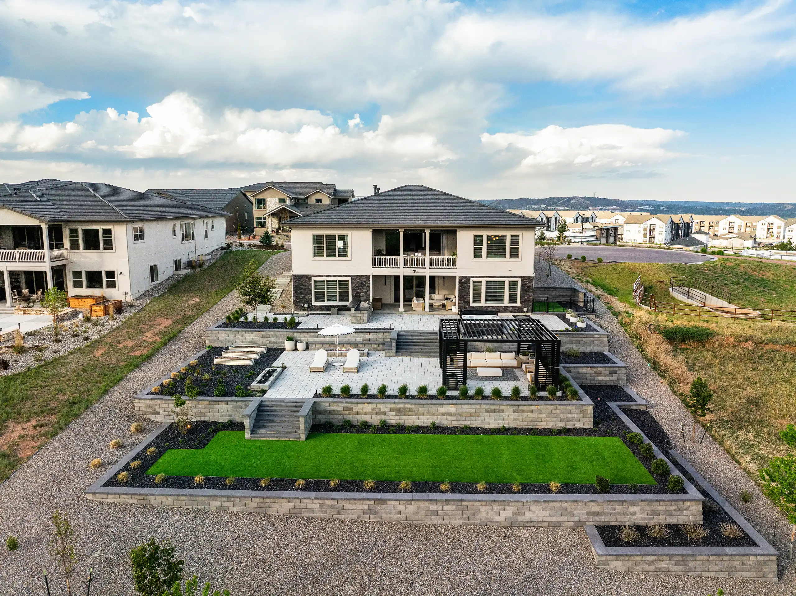 Aerial view of a multi-tiered backyard patio with stone retaining walls