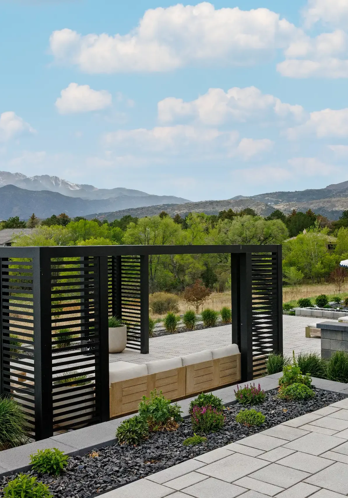 Modern patio featuring a black pergola lounge area and a hot tub.